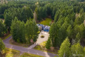 Overhead view facing southwest, showcasing entryway and private forest in back of the home.