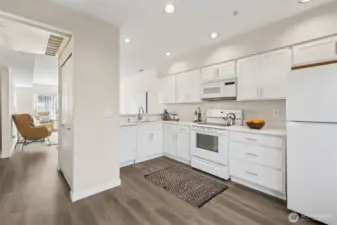 The kitchen has been thoughtfully updated with brand-new white cabinetry, offering a clean, timeless aesthetic that pairs beautifully with the fresh paint and new flooring throughout the main level.