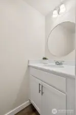 A refreshed half bath on the main level features a new white vanity cabinet, mirror & lighting, flooring and paint, adding both style and convenience for guests. Also nice in the summer when you are outside, and don't have to go upstairs to find a restroom!