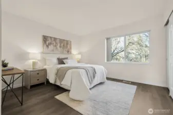 The primary suite features large closets and an attached three-quarter bath with updated finishes, including a new mirror, updated cabinet, tile countertop sink, and faucet. From here, enjoy tranquil views overlooking the backyard area, adding a sense of calm to your daily routine.