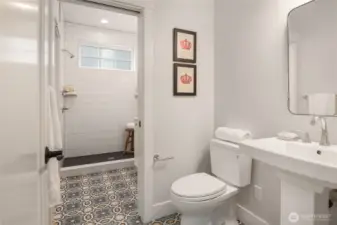 The main floor heated tile bath with pocket door separates the large shower with pedestal and 1.28 gallon Toto toilet.