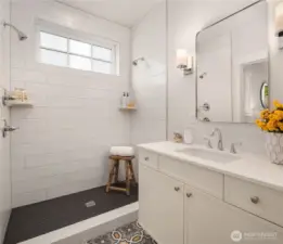 The large heated tile bath, tile shower and vanity adjoins the main floor primary bedroom.