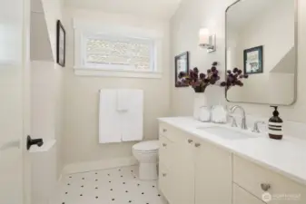 A large upstairs bath with tub features custom patterned tile and is shared by the two upstairs bedrooms.