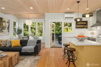 The generous living room, dining room and kitchen overlook the permanently preserved open space with Thornton Creek beyond.