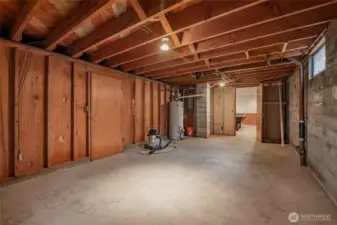Unfinished basement room with hot water heater and furnace.