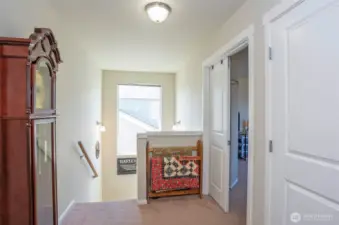 The upper-level landing is brightened by a large window midway up the stairs.