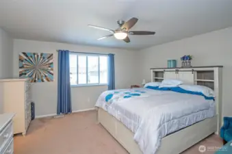 The huge window in the primary suite allows for an abundance of natural light, creating a warm and airy atmosphere.