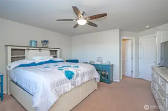 This view of the primary suite showcases the elegant ceiling fan, adding both comfort and style.
