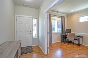 Upon entering the home, you'll find double doors to the right leading to a flexible space—perfect as a home office, den, or relaxing sitting area. Beautiful laminate flooring flows throughout the main level, adding warmth and style.