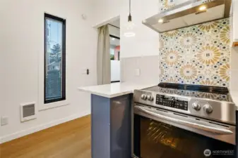 Custom tile backsplash behind stove and vent hood all the way to the ceiling