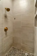 Fully tiled shower w/2 niches with natural stone accents