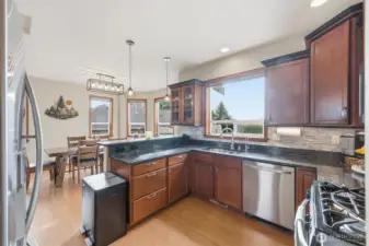 The kitchen's large window looks out into the large fenced backyard