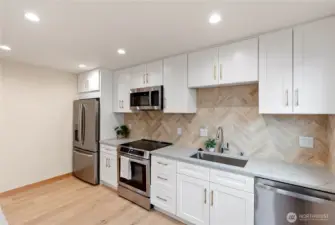 From the dining room enter into the full custom kitchen, complete with quartz countertops and stainless steel appliances.