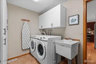 Main floor laundry/mud room features utility tub and extra storage.