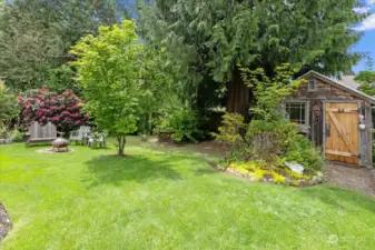 Back yard features large garden shed and fire pit.