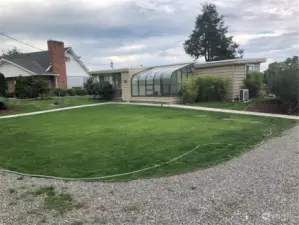 Coming down the driveway from Puget Beach, this is the home.   The atrium could also be a greenhouse or a hot tub/spa room.  You decide.