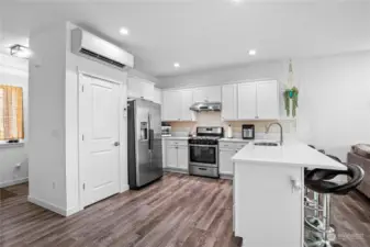 This kitchen is a cook's delight with stainless appliances, quartz countertops, and an extended eating bar.