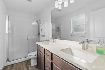 Private bath with dual sink vanity and a large step-in shower, off the primary bedroom.