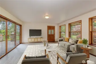 Virtual Staged Living room with sliding doors to deck.  Surrounded by windows to enjoy the lovely surroundings.