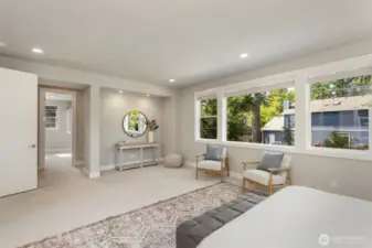 From this angle, the expansive primary suite reveals a cozy reading nook and a sunlit path leading to the luxurious en suite bath and walk-in closet. Clean lines, recessed lighting, and oversized windows create a tranquil, elevated space designed for everyday indulgence.
