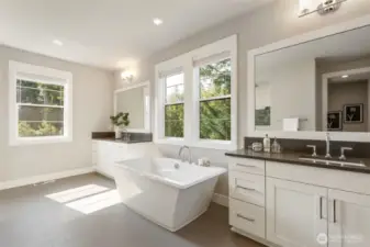 The spa-inspired primary bath offers a tranquil escape with a luxurious soaking tub framed by sun-filled windows, dual vanities with sleek quartz counters, and a soothing palette of soft neutrals. Thoughtfully designed for both relaxation and function, this serene space invites you to unwind in style.