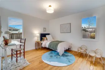 Bright and cheerful second bedroom with gleaming refinished hardwood floors, two large windows flooding the room with natural light, fresh paint, and a modern ceiling fixture. Plenty of space for a bed, desk, and play area – perfect as a guest room, home office, or kids’ room. Fully updated and move-in ready.