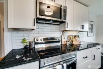 Brand-new stainless steel electric range with smooth-top cooktop, over-the-range microwave with built-in vent.