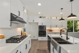 Kitchen Detail: Designer kitchen with sleek cabinetry, gas cooktop, double ovens, and custom tile backsplash, blending beauty with everyday efficiency. Thoughtful design provides plenty of prep and storage space. Staged photos are of the model home of the same floorplan within the Foxmoore community and are for visualization purposes only. Colors, finishes, and layout can and will vary.