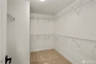 Primary Walk-In Closet: An expansive walk-in closet provides abundant hanging space and shelving to keep wardrobes organized with ease. Its size and layout allow for flexible storage solutions that fit modern lifestyles. Staged photos are of the model home of the same floorplan within the Foxmoore community and are for visualization purposes only. Colors, finishes, and layout can and will vary.