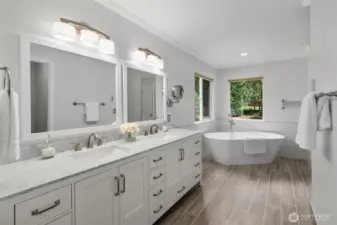 Modern bathroom has dual vanity and soaking tub.