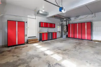 Three-car garage with newer furnace and tankless water heater.  To the right of the door are some built-in cabinets with work space and extra sink.