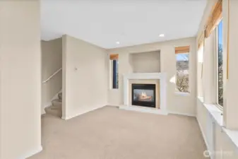 Living room featuring a gas fireplace, tall windows with blinds, recessed lighting, and carpeted flooring.