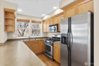 Kitchen featuring a double-basin sink, wood cabinets, stainless steel appliances, and windows with blinds.