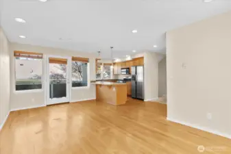 Kitchen with wood cabinetry, stainless steel appliances, pendant lighting, and access to a balcony through a glass door.