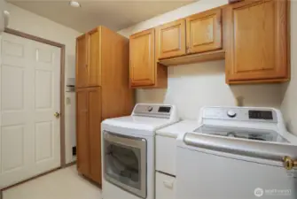 Off of the kitchen/great room area is your utility room and garage.  With lots of storage, your laundry room stays neat and tidy and bonus!  In the left hand cabinet is equipment for the surround sound stereo system in the great room.