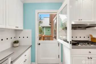 Fanciful doors galore! Dutch door pictured here, pocket doors in the kitchen, and a smart original privacy door to the bedroom hallway.
