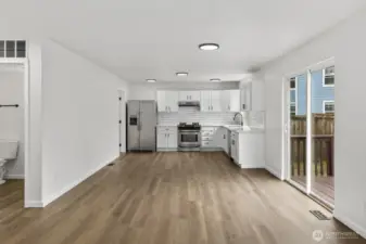 The updated kitchen, completed in 2021, features stainless steel appliances, sleek painted cabinetry, and elegant countertops.