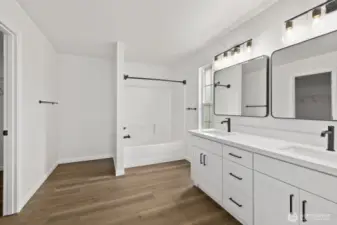 Welcome to the primary bath! This deceptively spacious room features a brand-new double vanity, along with new fixtures, lighting, and mirrors.
