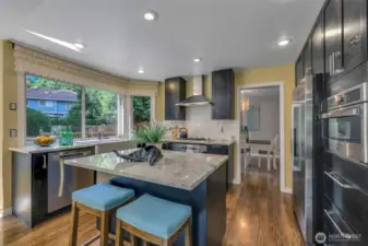 This thoughtfully designed kitchen blends form and function with gas cooking, tile backsplash, and rich cabinetry. A large corner window invites natural light and backyard views into your daily routine.