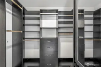 A custom walk-in closet system maximizes storage and organization, with built-in drawers, shelves, and hanging space designed to keep everything in its place.