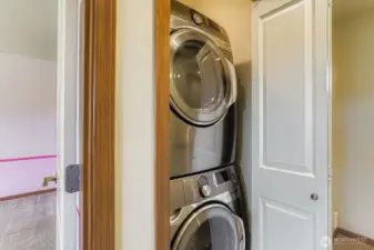 Utility closet with stackable washer an dryer that come with the home.