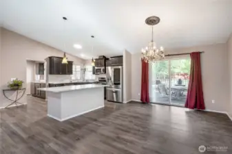The generously sized kitchen island offers room to sit and dine, or you can utilize the more formal dining area which overlooks the spacious deck. To the right, you see the wall which separates the separate apartment suite to the side, which also has its own private entry.