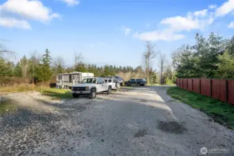 Your new estate includes the land inside the fence on the right, and the property you see to the left of it. Outside the fenced private backyard is the gravel access to the RV spaces and laundry building (not shown) which the sellers put in for visitors. They considered renting these out, but didn't pursue permits as they were moving. Utilities and even a holding tank is in place. How will you utilize all this developed space?