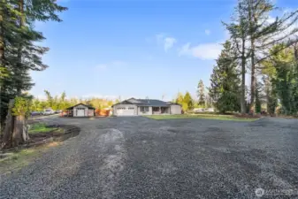 This vantage shows how the private graveled road encircles the home and the spacious fenced private backyard. It accesses the six RV sites and laundry building in the back, yet you don't see them from the front. How will you use all this amazingly developed space?