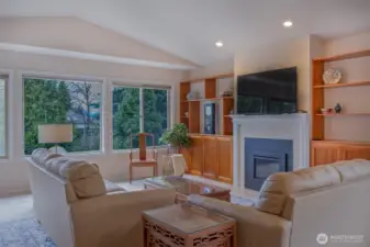 Living room with large windows-surrounded with natural greenery.