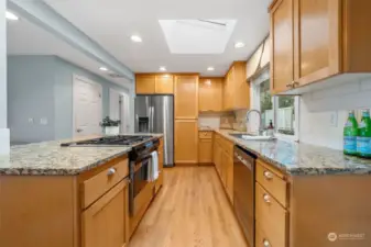 The kitchen is an entertainer's delight! It features solid wood cabinets, gas range, hardwood floors, granite countertops, a stainless steel appliance package and a skylight for ample light.