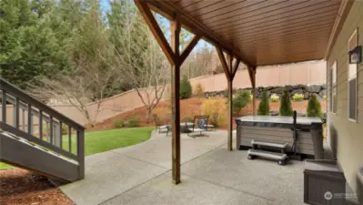 Covered backyard patio with hot tub