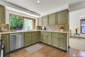 Renovated kitchen with oak hardwood floors, granite counters and tile backsplash. Large windows provide lovely backyard views.