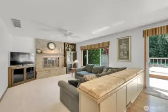 Additional bench seating with built-in storage backing to family room with beautiful updated stone fireplace surround and built-ins.