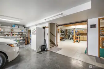 A view from the garage with interior roll up garage door into the workshop.